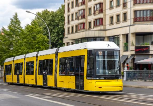 yellow-tram-gliding-past-curved-facade-urban-public-transport