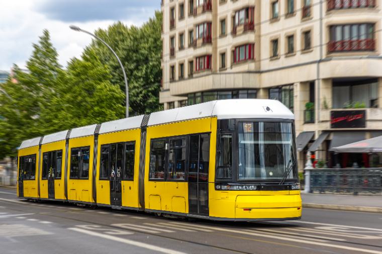 yellow-tram-gliding-past-curved-facade-urban-public-transport